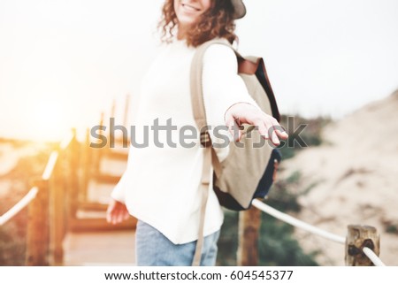 Young woman traveler guiding through the natural sand reserve, follow the leader, soft focus on fingers