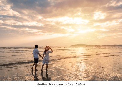 Young woman traveler holding man's hand and looking beautiful sunset on the beach, Couple on vacation in summer concept - Powered by Shutterstock