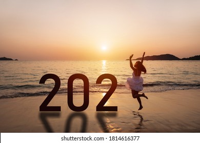 Young Woman Traveler Jumping At The Beach Celebrating New Year 2021 At Sunset