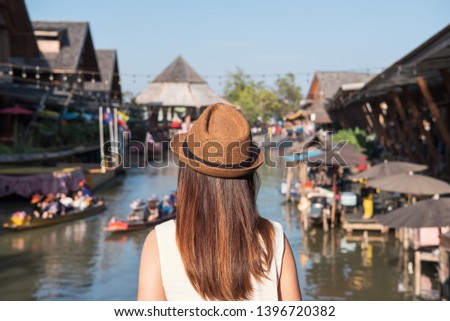 Young woman traveler looking at floating market in Thailand, Travel lifestyle concept