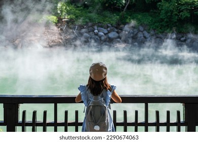 Young woman traveler looking at Hot spring pond at Xinbeitou thermal valley in Taiwan