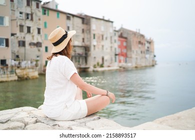 Young woman traveler looking at the sea in Rovinj town, Istria region, Croatia. Travel and active lifestyle concept