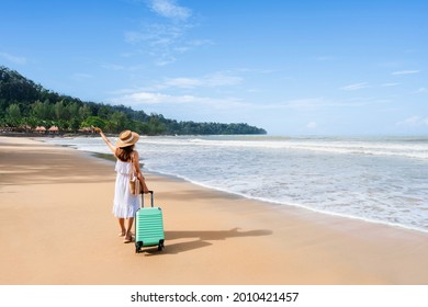 Young Woman Traveler With Luggage Relaxing And Enjoying On Tropical Beach In Sunny Day, Summer Vacation And Travel Concept