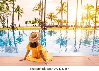 Young Woman Traveler Relaxing And Enjoying The Sunset By A Tropical Resort Pool While Traveling For Summer Vacation