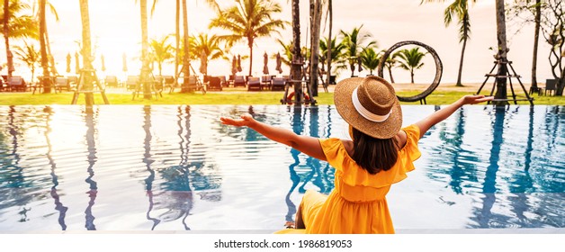 Young Woman Traveler Relaxing And Enjoying The Sunset By A Tropical Resort Pool While Traveling For Summer Vacation