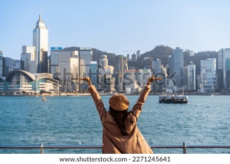 Young woman traveler relaxing and enjoying the sunset atmosphere at Victoria harbour in Hong Kong