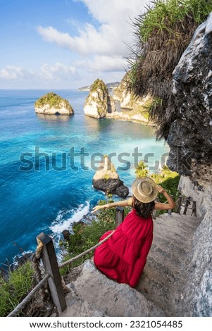 Young woman traveler relaxing and enjoying the beautiful view at diamond beach in Nusa Penida island, Bali
