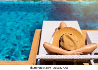 Young woman traveler relaxing at the resort pool while traveling for summer vacation