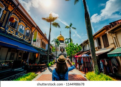 Young woman traveler traveling into The Masjid Sultan mosque located in Kampong Glam in Singapore city.