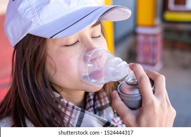 Young Woman Traveler Using Oxygen Can And Breathing For Prevent Altitude Mountain Sickness