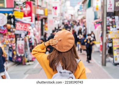 Young woman traveler walking on the Takeshita street in Harajuku the center of teenage fashion and cosplay culture in Tokyo - Shutterstock ID 2218190743
