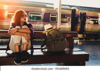 Young Woman Traveler Wearing Backpack Waiting Railway At Train Station, Summer Holiday And Travel Concept
