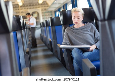 Young Woman Traveling By Train, Conductor Checking  Tickets In The Background.