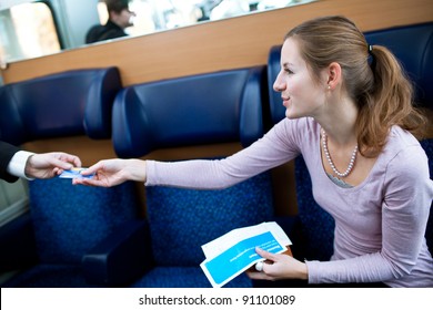 Young Woman Traveling By Train, Having Her Ticket Checked By The Train Conductor