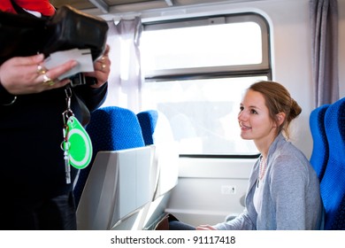 Young Woman Traveling By Train, Having Her Ticket Checked By The Train Conductor