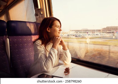 Young woman traveling  looking out the window while sitting in the train. - Shutterstock ID 258798260