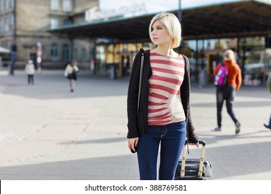 Young woman traveling with a wheeled suitcase