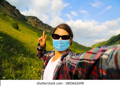 Young woman traveller wearing face mask outside at the nature and taking selfie at the mountains in Caucasus Russia.	 - Powered by Shutterstock