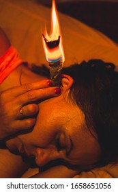 Young Woman Treats Ear In Natural Way With Wax Candles.