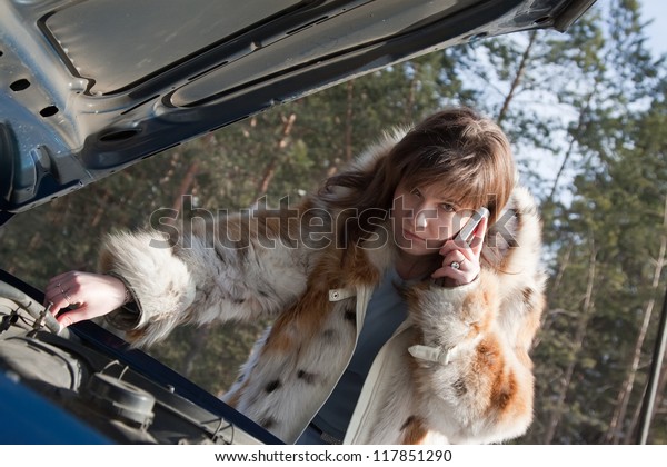 Young woman trying to fix the\
car