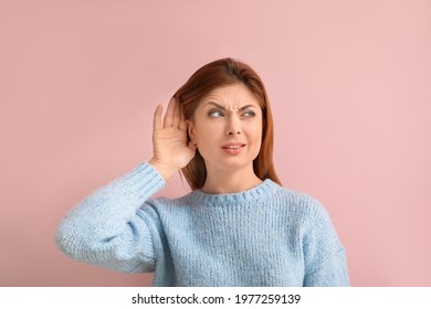 Young Woman Trying To Hear Something On Color Background