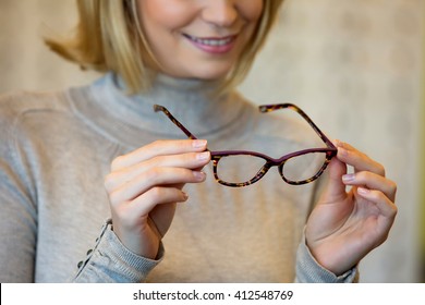 Young Woman Trying On Glasses