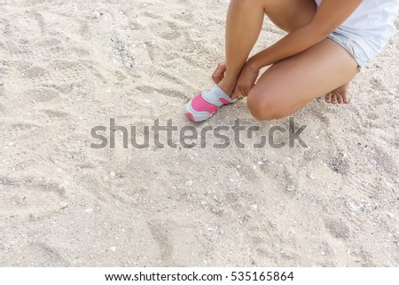 Young woman trying to put on smaller size of shoes 