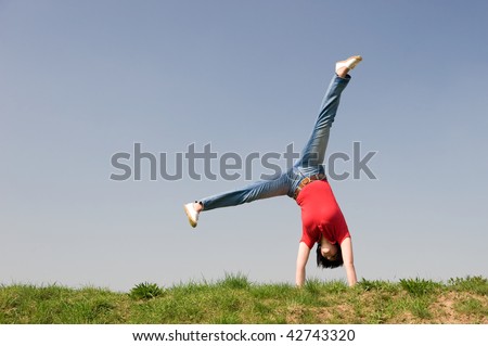 Young woman is turning a cartwheel