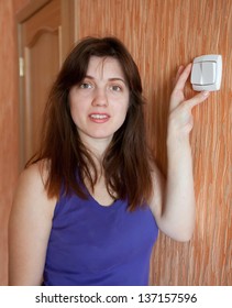 Young Woman Turning Off The Light Switch