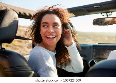 Young Woman Turning Round In Front Passenger Seat Of A Car