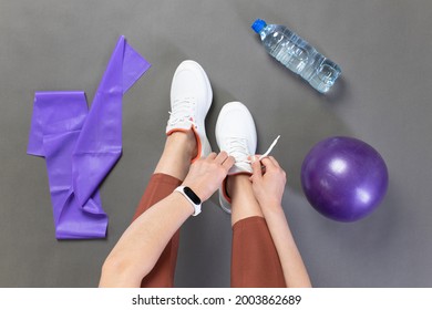 Young Woman Tying Shoelace Before Workout, Getting Ready For Pilates Workout