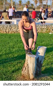 Young Woman Tying Sneakers Before Running Outdoors