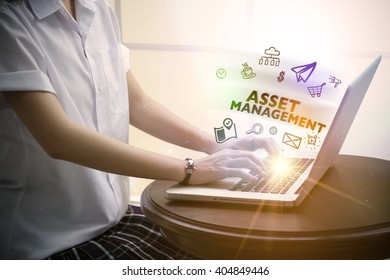 Young Woman Typing ASSET MANAGEMENT Over Notebook Computer With And Icon , Business Concept 