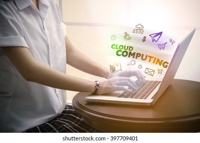 Young woman typing  CLOUD COMPUTING over notebook computer with and icon , business concept 