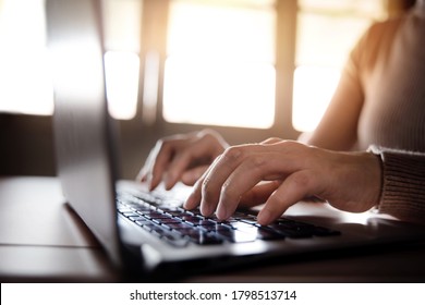 Young Woman Typing Computer Laptop Keyboard. Closeup shot and Selective focus on Finger. Working on Desk against Window
