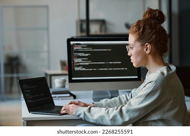 Young woman typing programming codes