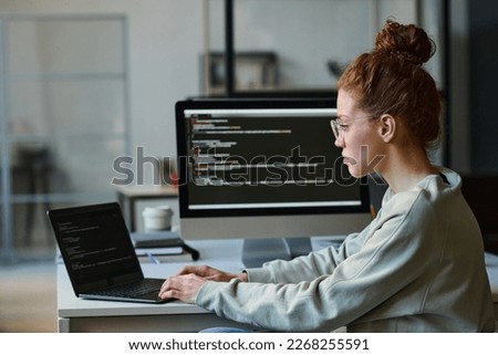 Young woman typing programming codes