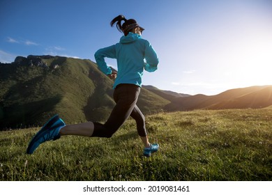 Young woman ultramarathon runner running at mountain top - Shutterstock ID 2019081461