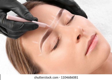 Young Woman Undergoing Eyebrow Correction Procedure In Salon