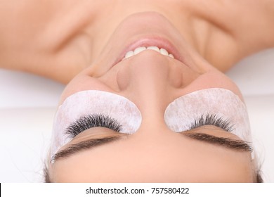 Young woman undergoing eyelash extension procedure, closeup