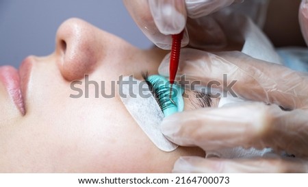Young woman undergoing eyelash tinting and lamination procedure.