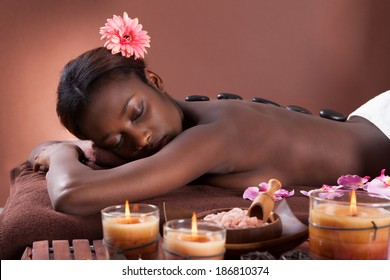 Young woman undergoing lastone therapy at beauty spa