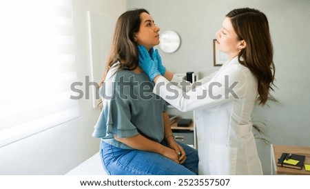 Young woman is undergoing a medical check-up as a doctor gently palpates her lymph nodes