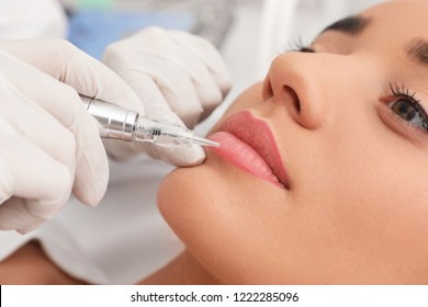 Young Woman Undergoing Procedure Of Permanent Lip Makeup In Tattoo Salon, Closeup