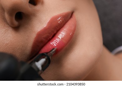 Young woman undergoing procedure of permanent lip makeup in tattoo salon, top view
