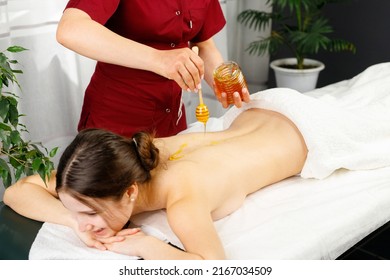 Young woman undergoing spa treatment with honey in spa salon for relaxing skin and keep body in shape. - Powered by Shutterstock