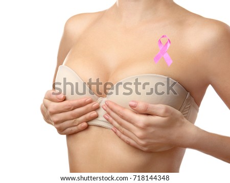 Young woman in underwear with pink ribbon on white background. Breast cancer concept