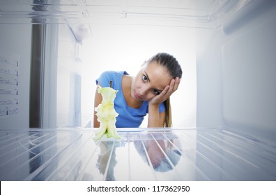 Young Woman Unhappy To See The Empty Fridge