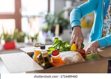 Young woman unpacking boxes of food at home
 - Shutterstock ID 1716489460