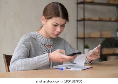 Young woman upset counting the amount of purchases in the store on a sales receipt - Shutterstock ID 1904587936